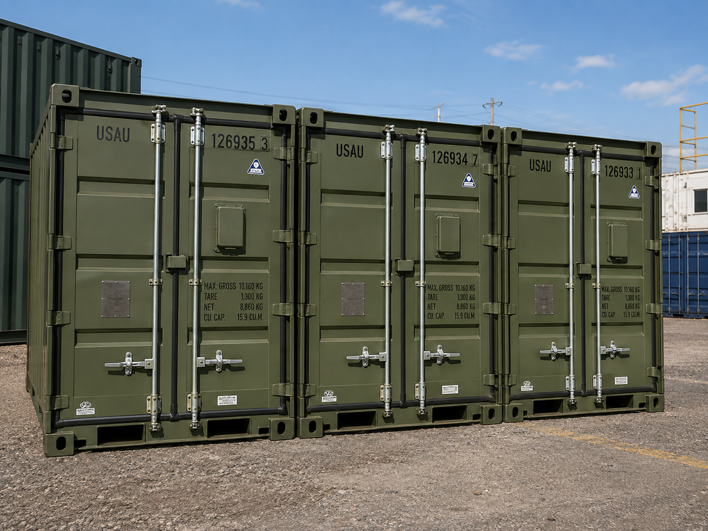 Three olive-drab Tricon military modular containers coupled in a row, each marked with USAU owner code and CSC safety approval plate
